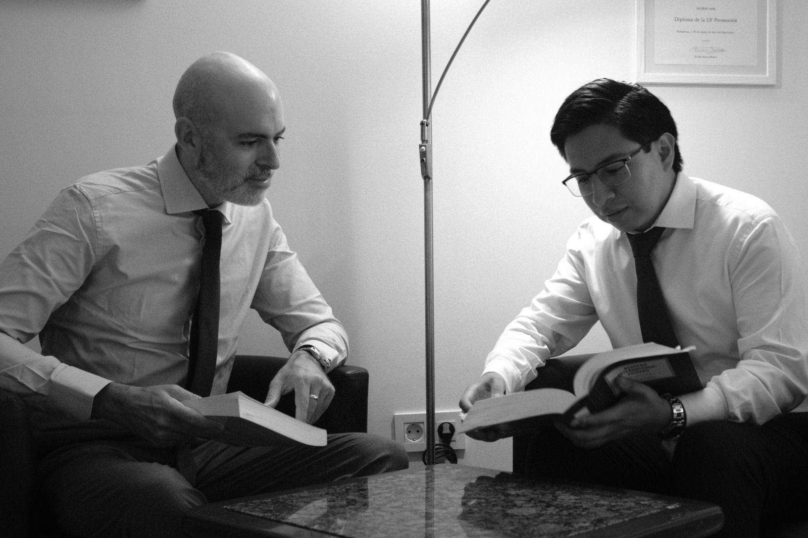 Dos socios de SOG Abogados consultando manuales jurídicos en el despacho