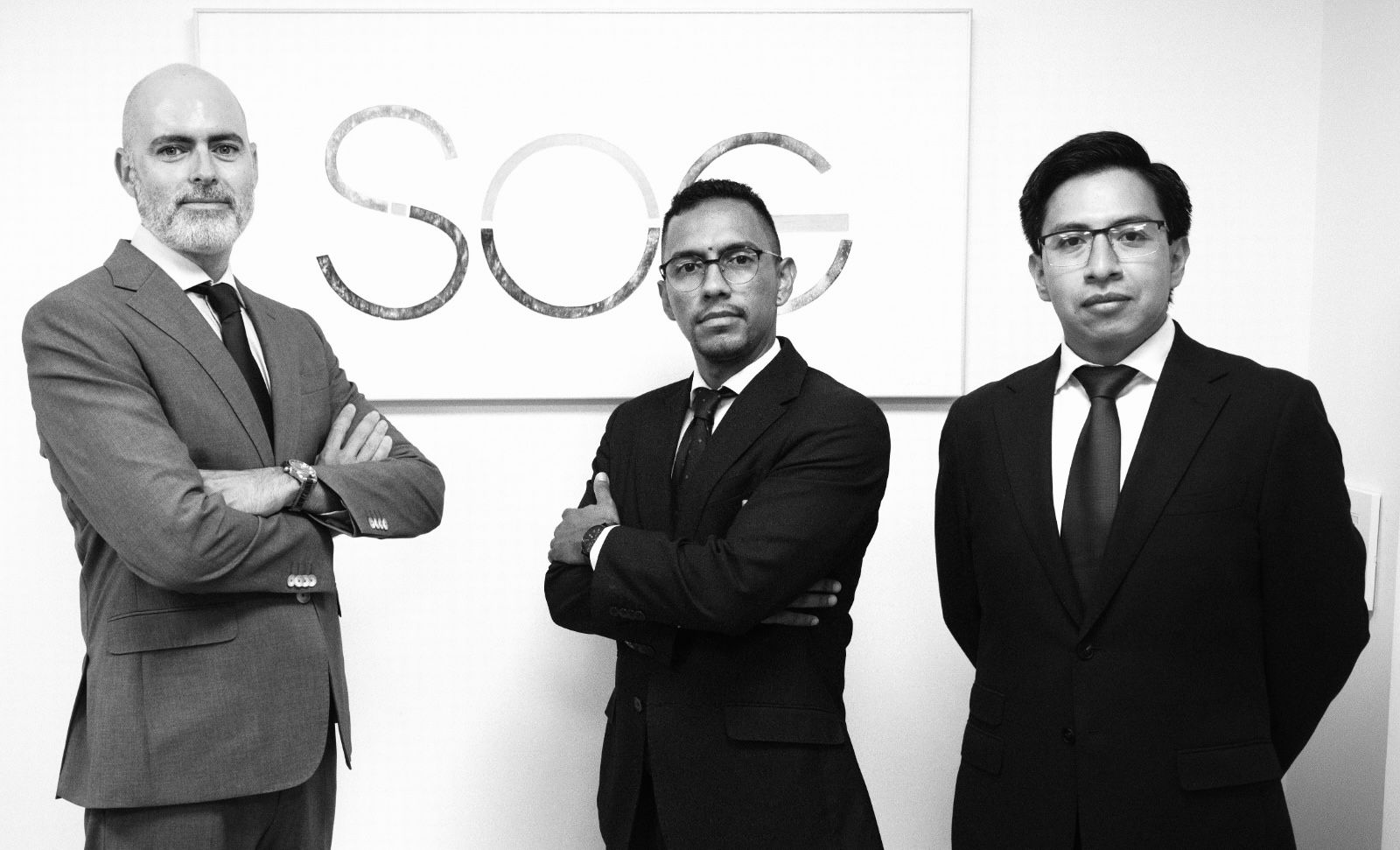 Los tres socios de SOG Abogados frente al logotipo del despacho