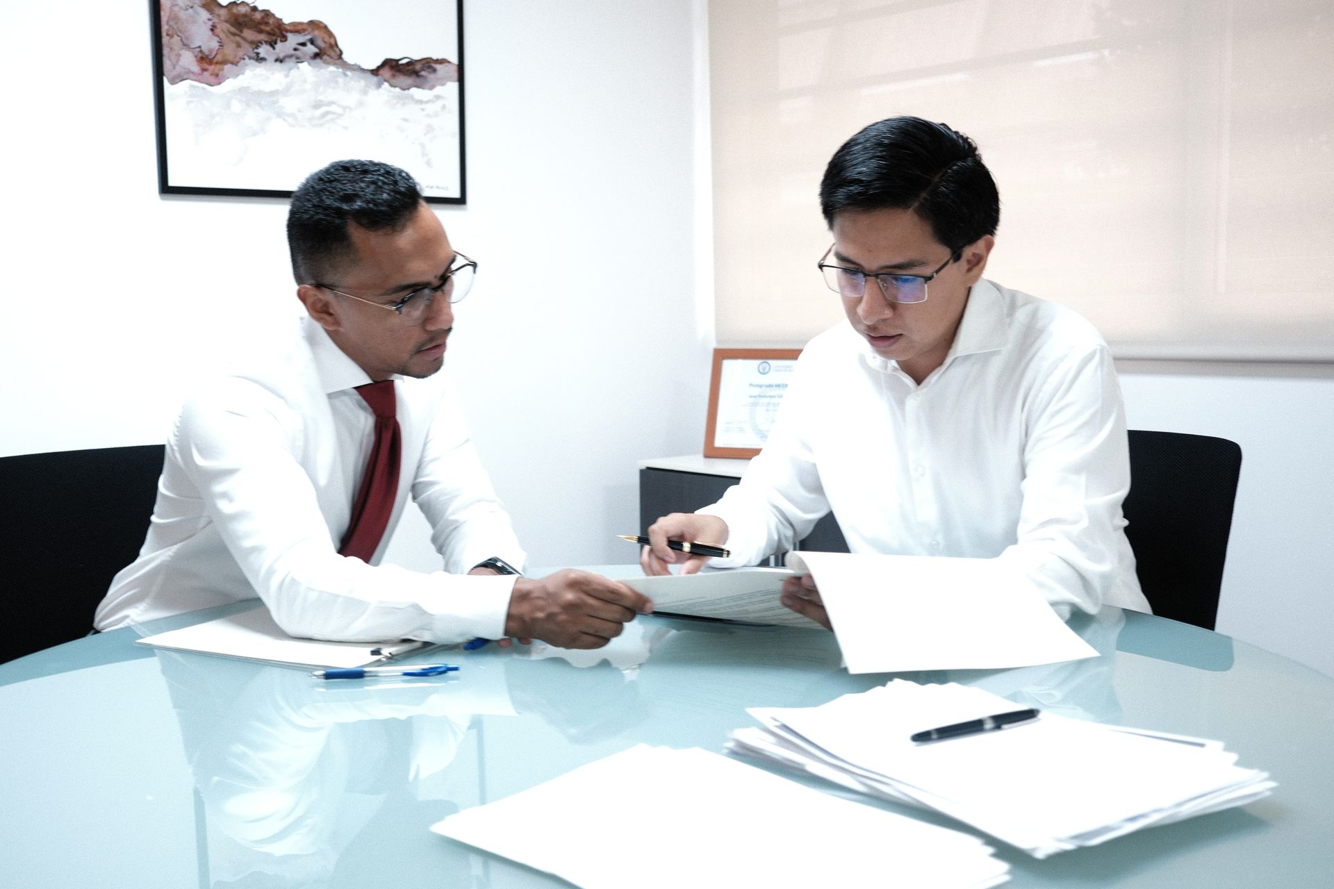Dos abogados de SOG revisando documentación en la sala de reuniones